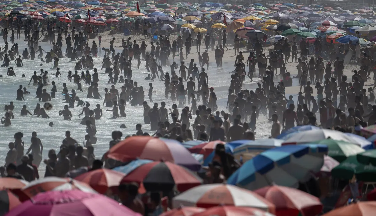 Suhu panas memaksa ribuan orang memenuhi area pantai Copacabana di Rio de Janeiro, Brasil untuk menyejukkan diri. (Pablo PORCIUNCULA/AFP)