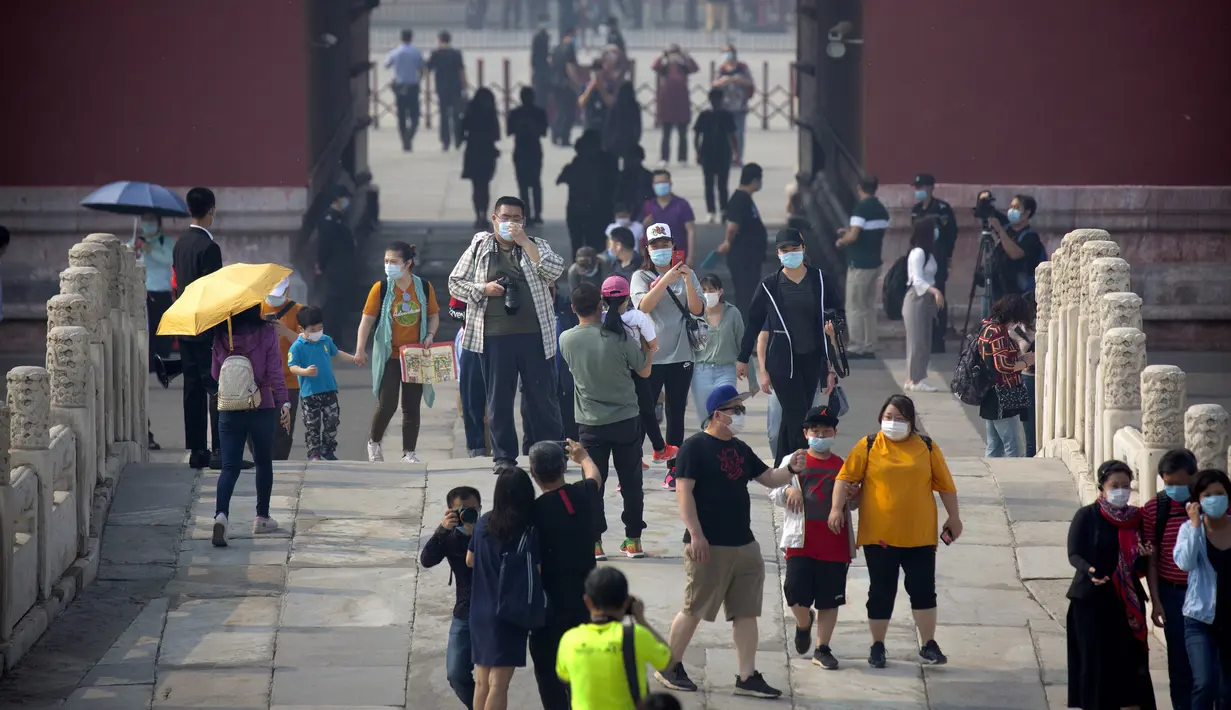 Para pengunjung mengenakan masker saat mengunjungi Kota Terlarang, Beijing, China, Jumat (1/5/2020). Kota Terlarang kembali dibuka setelah ditutup lebih dari tiga bulan karena pandemi virus corona COVID-19. (AP Photo/Mark Schiefelbein)