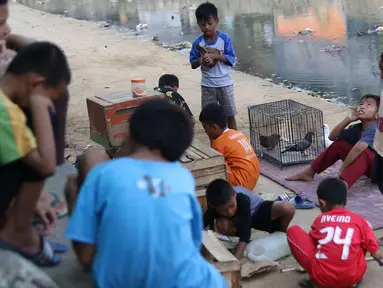 Anak-anak bermain di bantaran anak Sungai Ciliwung, Jakarta, Rabu (6/6). Meskipun tidak layak sebagai tempat bermain, namun lokasi itu menjadi tempat bagi anak-anak di kawasan tersebut untuk menunggu waktu berbuka. (Liputan6.com/Immanuel Antonius)