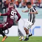 Striker Juventus, Paulo Dybala, berusaha melewati pemain Torino pada laga Serie A, Italia, di Stadion Allianz, Sabtu (23/9/2017). Juventus menang 4-0 atas Torino. (AFP/Filippo Monteforte)