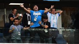 Legenda sepak bola dunia, Diego Maradona (tengah) merayakan gol yang dicetak Lionel Messi saat melawan Nigeria pada laga grup D Piala Dunia 2018 di Saint Petersburg Stadium, Saint Petersburg, (26/6/2018). Argentina menang 2-1. (AFP/Giuseppe Cacace)