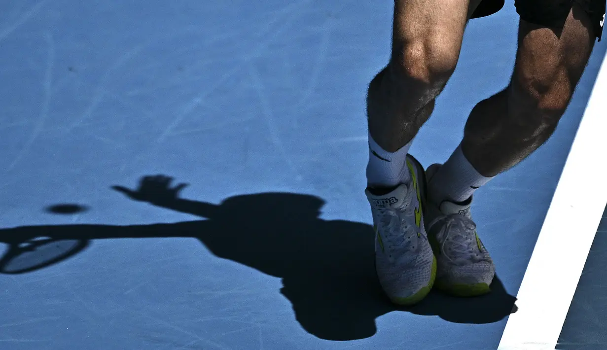 Petenis Spanyol, Pedro Martinez melakukan servis ke arah petenis Polandia, Hubert Hurkacz saat laga hari pertama Australian Open 2023 di Melbourne, Australia, Senin (16/01/2023). (AFP/Anthony Wallace)