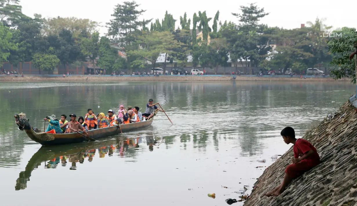 Pengunjung naik perahu naga di kawasan Setu Babakan, Jakarta, Minggu (23/6/2019). Ribuan warga memadati kawasan Setu Babakan untuk berwisata dan menyaksikan beragam acara dalam rangka perayaan HUT ke-492 Jakarta. (Liputan6.com/Helmi Fithriansyah)
