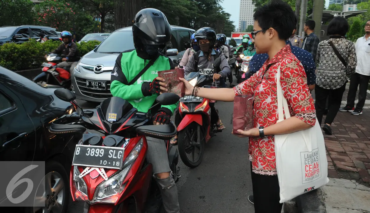 Petugas KPK memberikan takjil gratis kepada pengendara yang melintasi jalan HR Rasuna Said, Jakarta, Rabu (29/6). (Liputan6.com/Helmi Afandi)