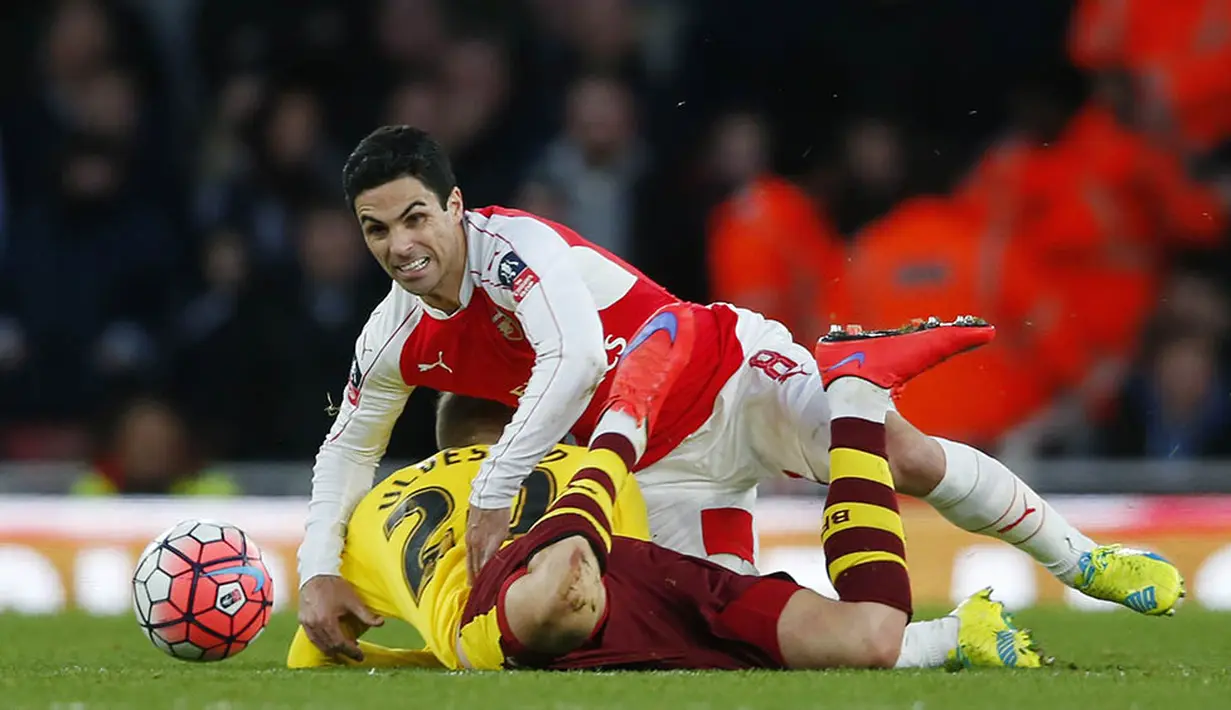 Gelandang Arsenal, Mikel Arteta, terjatuh saat berebut bola dengan pemain Burnley, Fredrik Ulvestad. Klub London itu melakukan 15 kali percobaan tendangan untuk mencetak gol. (Reuters/Eddie Keogh) 