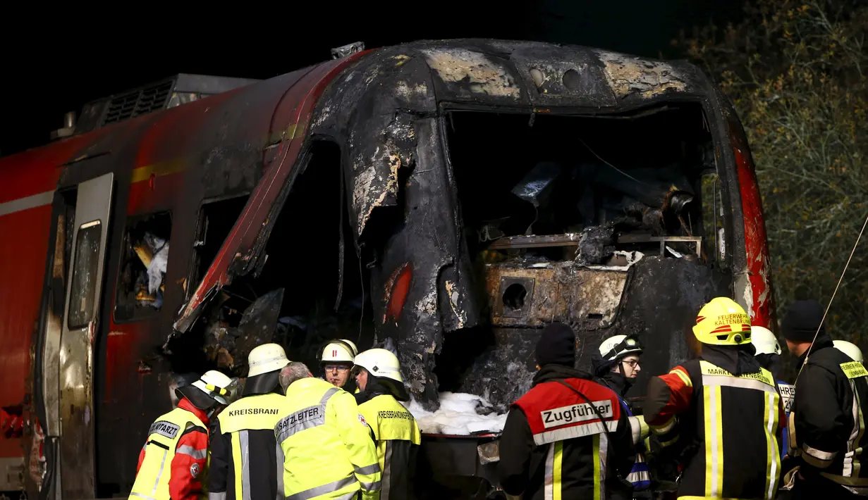 Petugas pemadam mencari masinis yang hilang usai sebuah kereta bertabrakan dengan truk milter di persimpangan kereta api di Freihung, Jerman, Kamis (5/11). Sedikitnya satu orang tewas dan beberapa lainnya terluka. (REUTERS / Michaela Rehle)