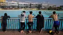 Pengunjung melihat peselancar di kolam ombak Wave Park di Siheung, Korea Selatan, 18 Oktober 2020. Kolam ombak terbesar di dunia ini merupakan bagian dari Siheung Surf Park, sebuah resor terletak di Pulau Penyu, yang akan mencakup sebuah hotel, pusat konvensi, marina, dan bianglala. (Ed JONES/AFP)