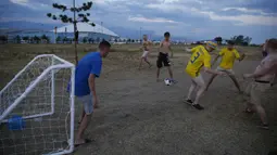 Sejumlah suporter Swedia bergembira bermain bola di sekitar Pantai Sochi, Jumat (22/6/2018). Para suporter bersiap untuk menyaksikan laga Piala Dunia 2018 antara Swedia melawan Jerman. (AP/Rebecca Blackwell)