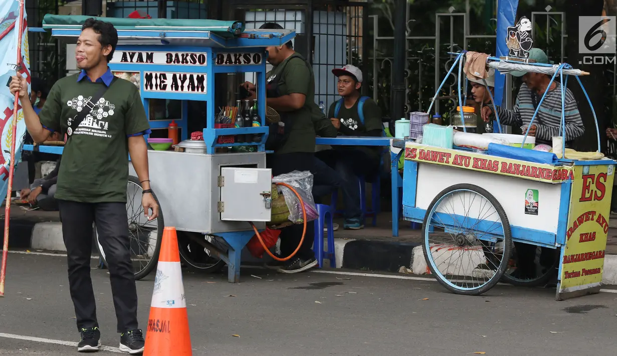Pedagang kaki lima menjajakan makanan dan minuman di sisi jalan sekitar kawasan Patung Kuda Jakarta, Rabu (5/1/2019). Mereka mencoba peruntungan saat para buruh melakukan aksi perayaan Hari Buruh International atau May Day. (Liputan6.com/Helmi Fithriansyah)