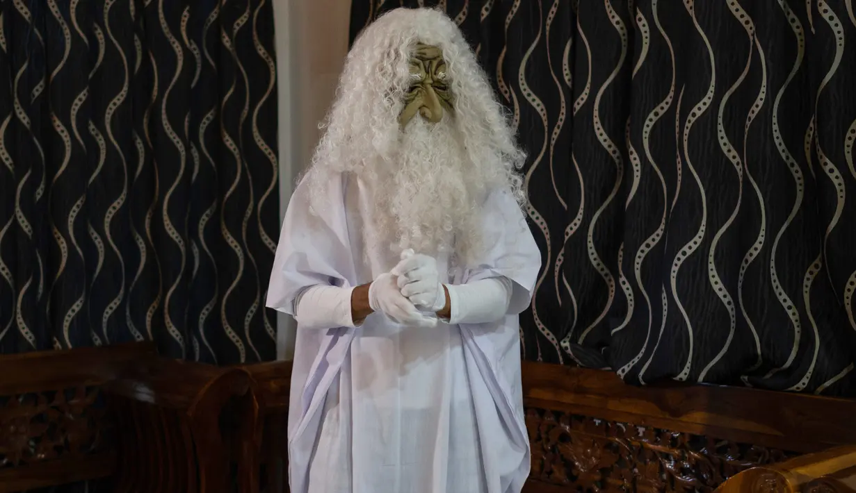 Urabil Alias, 38, mengenakan kostum hantu bersiap untuk berjalan di daerah perumahan selama aturan pembatasan gerakan atau Movement Control Order di Terengganu, Malaysia, 16 April 2020. Aksi pria itu untuk menakuti warga agar tidak keluar rumah selama lockdown akibat virus corona. (Mohd RASFAN/AFP)