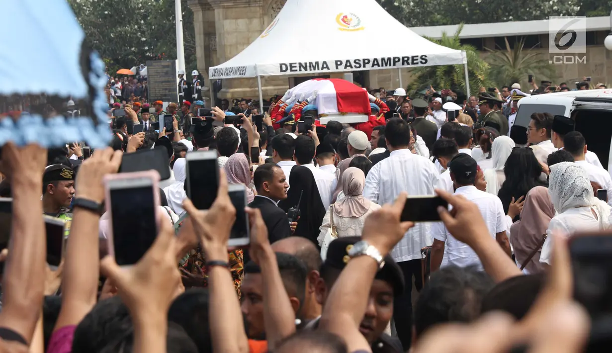 Warga berdesakan melihat prosesi pemakaman Presiden ke-3 RI BJ Habibie di TMP Kalibata, Jakarta, Kamis (12/9/2019). Upacara pemakaman Habibie dipimpin oleh Presiden Joko Widodo. (Liputan6.com/Helmi Fithriansyah)