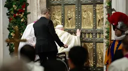 Paus Fransiskus menandai misa Natal 2024 dengan ritual istimewa pembukaan pintu suci Basilika Santo Petrus. (Remo Casilli/POOL/AFP)