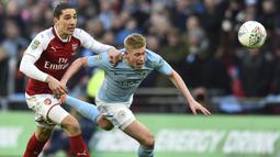 Gelandang Manchester City, Kevin de Bruyne, berebut bola dengan bek Arsenal, Hector Bellerin, pada final Piala Liga di Stadion Wembley, London, Minggu (25/2/2018). City menang 3-0 atas Arsenal. (AFP/Glyn Kirk)