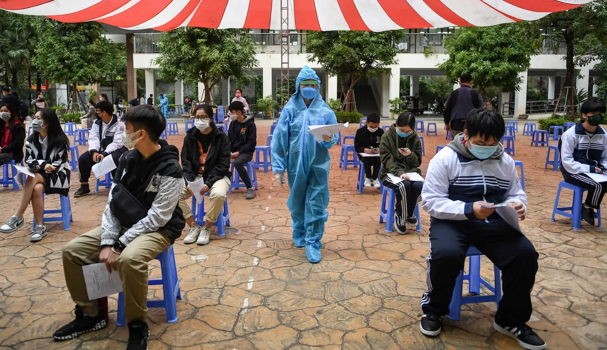 Anak-anak berusia 12 hingga 17 tahun menunggu untuk disuntik vaksin COVID-19 Pfizer/BioNTech di Hanoi, Vietnam, Selasa (23/11/2021). Menurut data Kementerian Kesehatan Vietnam, hampir 108 juta dosis vaksin COVID-19 telah disuntikkan kepada warga hingga Sabtu pekan kemarin. (Nhac NGUYEN/AFP)