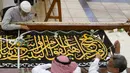 Pekerja menyulam kaligrafi Islam menggunakan benang perak murni atau benang perak berlapis emas pada tahap akhir pembuatan Kiswah Kabah di Mekah, Arab Saudi, 6 Juli 2022. Jemaah haji berkumpul di Kota Suci Mekah untuk haji terbesar sejak pandemi virus corona COVID-19. (AP Photo/Amr Nabil)