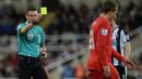 Wasit Andre Marriner memberi kartu kuning kepada pemain Liverpool, Lucas Leiva, dalam lanjutan Liga Inggris di Stadion St James' Park, Newcastle, Minggu (6/12/2015). (AFP/Oli Scarff)