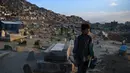 Afghan Zilgai (9), bocah penjual air ketika mencari pelanggan di pemakaman Kart-e-Sakhi, Kabul, 20 Februari 2016. Anak sulung dari 8 bersaudara itu menjual air dari fajar hingga senja kepada para peziarah (AFP PHOTO/Wakil KOHSAR)