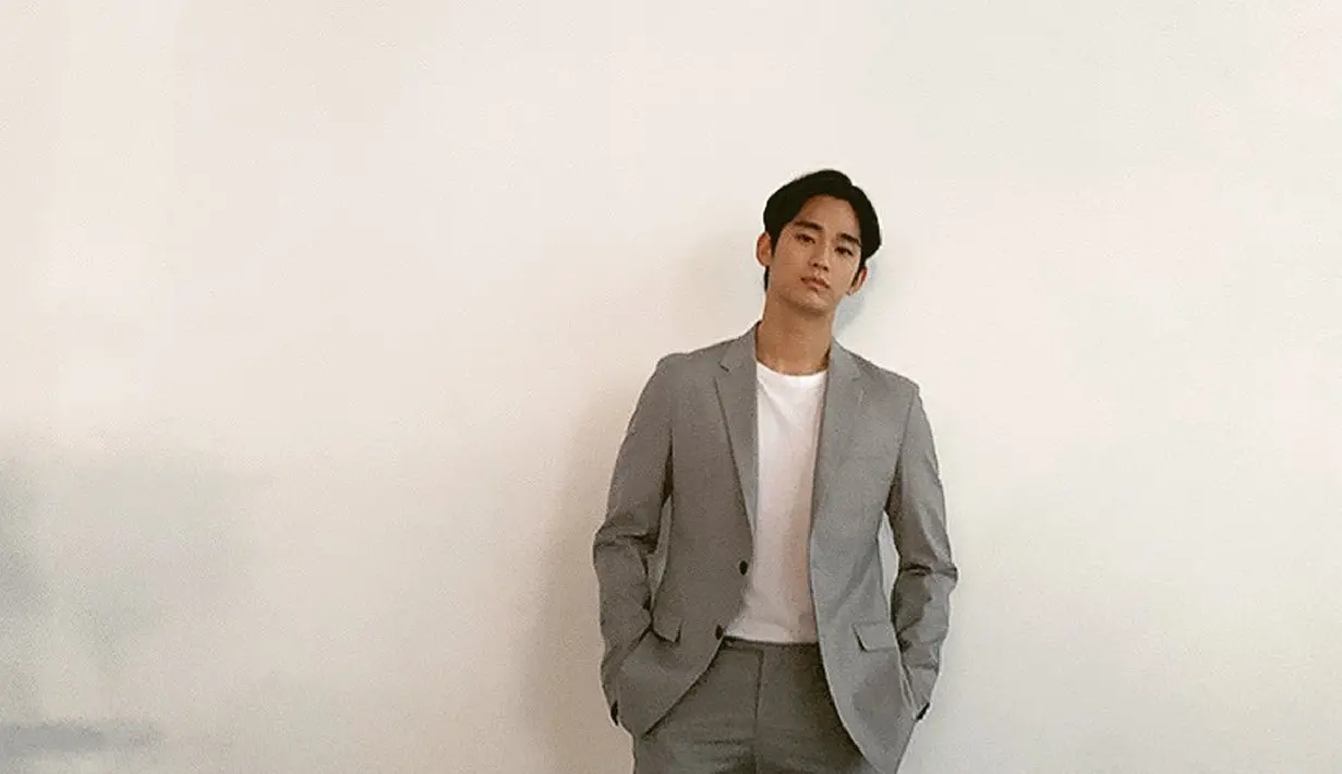 Office look Kim Soo Hyun dengan kaus putih ditumpuknya mengenakan setelan blazer dan celana panjang abu-abu. [Foto: Instagram/soohyun_k216]