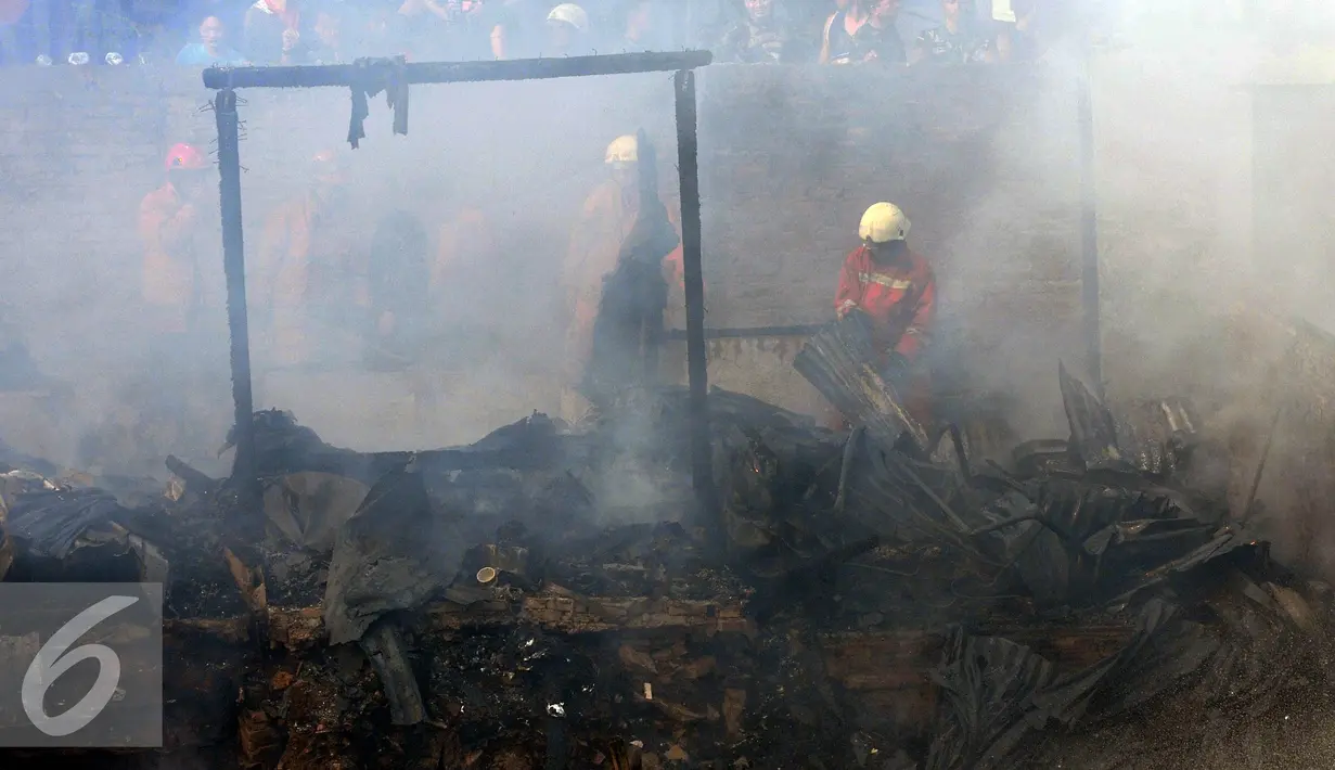 Petugas mengevakuasi saat terjadinya kebakaran yang melanda rumah hunian semi permanen di bantaran sungai anak kali ciliwung, Kawasan Kampung Berland, Jakarta, Rabu (2/9/2015). (Liputan6.com/Johan Tallo)