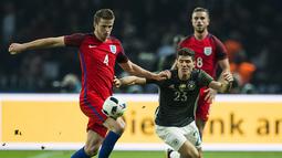 Bek Inggris, Eric Dier, menghadang laju striker Jerman, Mario Gomes, pada laga persahabatan di Stadion Olimpiastadion, Berlin, Sabtu (26/3/2016). Jerman takluk 2-3 dari Inggris. (AFP/Odd Andersen)