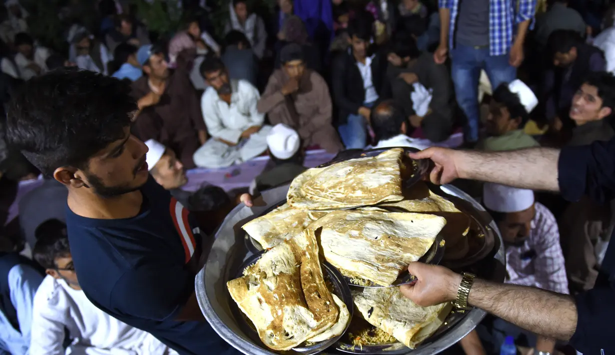Panitia membagikan makan berbuka puasa kepada umat muslim di sebuah masjid di Kabul, Afganistan, 16 Juni 2016. Tradisi berbuka puasa bersama selama Ramadan merupakan momentum untuk mempererat tali persaudaraan. (Wakil Kohsar/AFP)