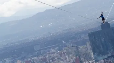 Alexander Schultz, asal Jerman mulai berjalan di antara dua gedung tertinggi Mexico City menggunakan tali pada ketinggian 246 meter di Meksiko, 4 Desember 2016. Schultz butuh lima kali usaha menaklukkan tali sepanjang 217 meter itu. (REUTERS/Stringer)