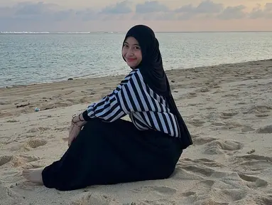 Adik dari Abidzar ini beberapa waktu lalu unggah foto di pantai. Ia tampak menikmati suaana pantai yang menuju ke waktu sunset. Momen Adiba duduk di pasir ini sungguh bikin adem lihatnya. (Liputan6.com/IG/adiba.knza)