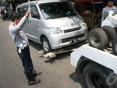 Sebuah mobil diderek petugas Dishub karena parkir sembarangan di jalan Pramuka, Jakarta, Kamis (18/9/2014) (Liputan6.com/Faizal Fanani)