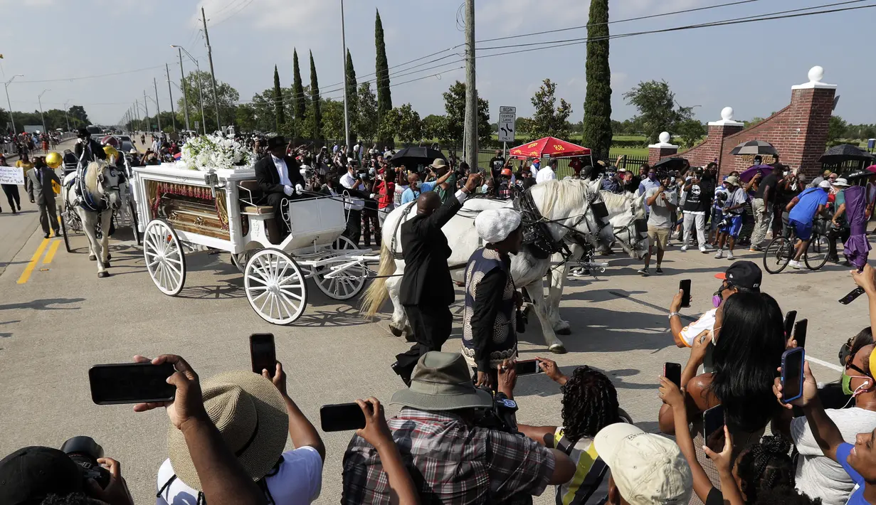 Orang-orang menyaksikan kereta kuda membawa jenazah George Floyd menuju pemakaman Houston Memorial Gardens di Houston, Texas, Amerika Serikat, Selasa (9/6/2020). Floyd akan dimakamkan di samping makam ibunya, Larcenia Floyd. (AP Photo/Eric Gay)
