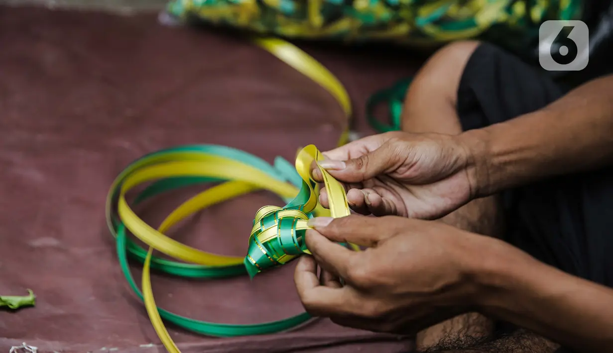 Pedagang menjalin pita untuk membuat pernak-pernik ketupat hias di Pasar Asemka, Jakarta, Selasa (4/5/2021). Pedagang mulai menjual pernak-pernik menjelang Lebaran seperti ketupat hias dengan harga mulai dari Rp15.000 hingga Rp60.000 tergantung ukuran. (Liputan6.com/Faizal Fanani)