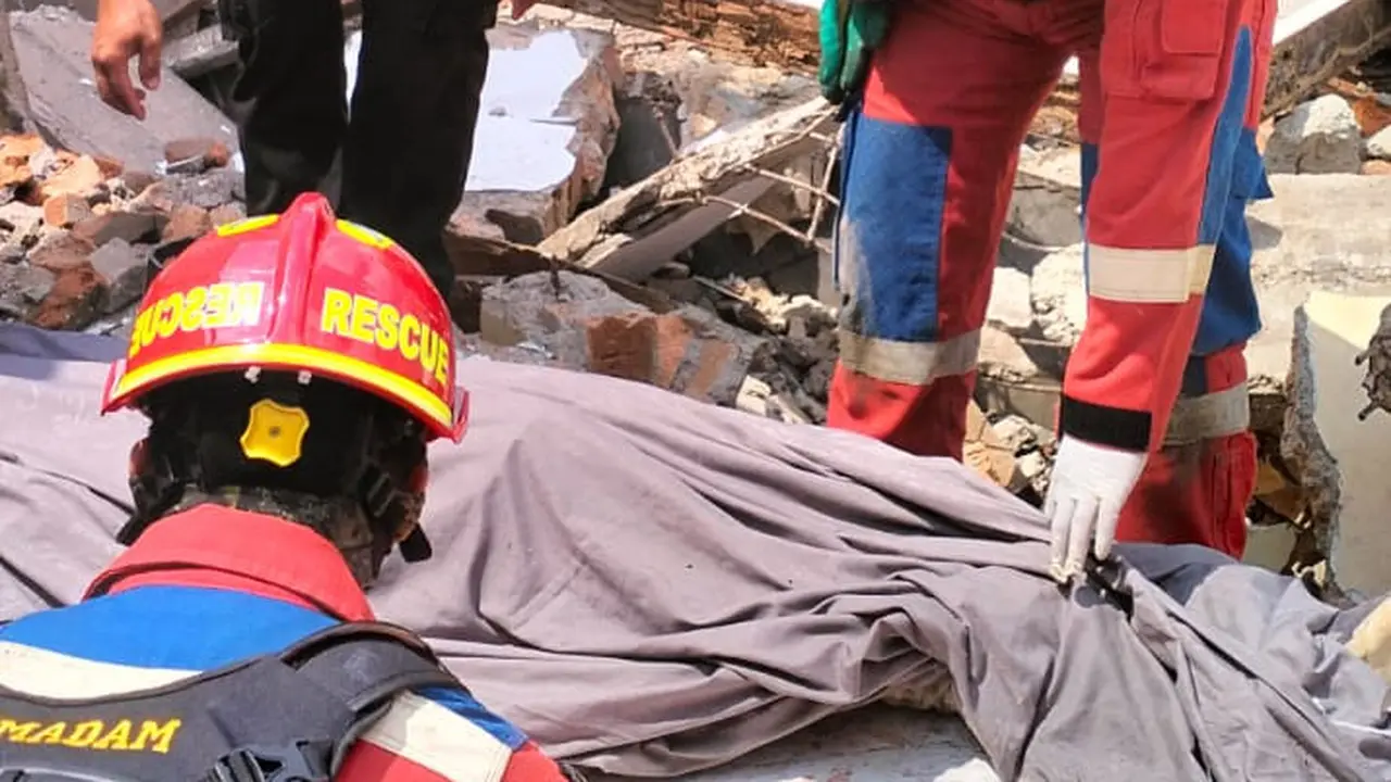 Petugas Gulkarmat Jakarta Timur saat mengevakuasi korban bangunan roboh di Kramat Jati, Jakarta Timur.