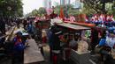 Pedagang kaki lima menjajakan barang dagangan saat Demo Hari Buruh di Jakarta, Selasa (1/5). Pedagang kaki lima ini memanfaatkan Hari Buruh untuk mengais rejeki dengan berjualan saat demontrasi berlangsung. (Liputan6.com/Johan Tallo)