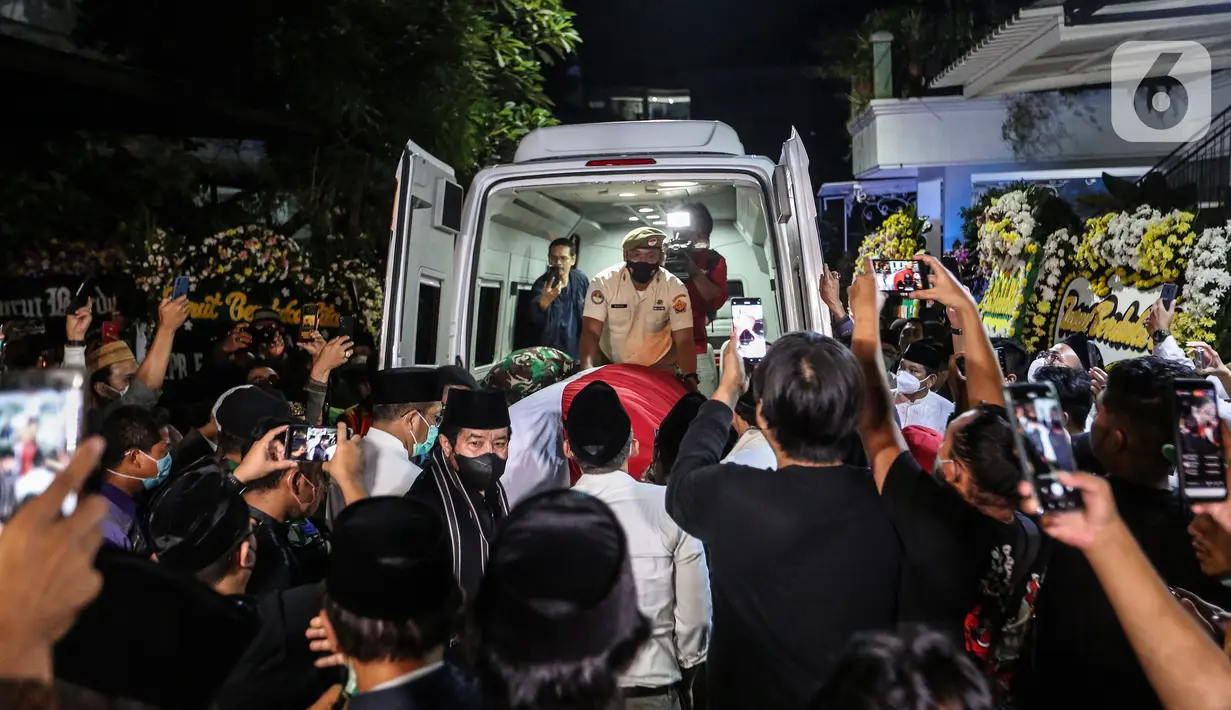 Saudara serta Kerabat mengangkat Peti Jenazah Ketua Dewan Pers Azyumardi Azra di rumah duka di Perumahan Puri Laras II, Cirendeu, Tangerang Selatan, Senin (19/9/2022) tengah malam. Azyumardi Azra meninggal dunia pada Minggu (18/9/2022) di rumah sakit Kedah, Selangor, Malaysia pukul 12.30 waktu setempat, dan rencana akan dimakamkan Selasa (20/9/2022) di Taman Makam Pahlawan (TMP) Kalibata. (Liputan6.com/Johan Tallo)