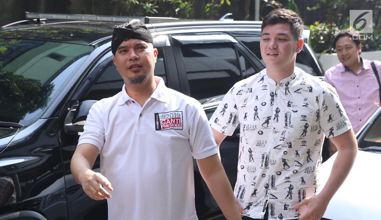 Seniman, Dhani Ahmad Prasetyo (kiri) bersiap membuat pelaporan tentang dugaan persekusi di Bareskrim Mabes Polri Gedung KKP, Jakarta, Jumat (19/10). Dhani Ahmad merasa mendapat perlakuan persekusi saat berada di Surabaya. (Liputan6.com/Helmi Fithriansyah)