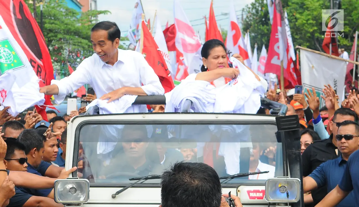 Capres 01 Joko Widodo didampingi Istri Iriana Joko Widodo membagikan kaos saat kampanye terbuka di Banyumas, Jawa Tengah, Kamis (4/4). Dalam kampanye tersebut Jokowi mengajak para pendukung untuk memerangi hoax dan memenangkan pasangan no urut 01 Jokowi-ma'ruf di banyumas.(Liputan6.com/Angga Yuniar)