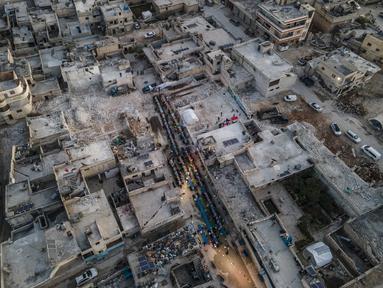 Penduduk setempat di kota Atareb di pedesaan barat provinsi Aleppo yang terkena dampak gempa 6 Februari menghadiri buka puasa bersama di bulan Ramadhan.  Gempa berkekuatan Magnitudo 7,8 yang terjadi menewaskan hampir 6.000 orang di Suriah dan puluhan ribu lainnya di negara tetangga Turki.