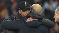 Pelatih Liverpool, Jurgen Klopp memeluk pelatih Manchester City, Pep  Guardiola usai pertandingan lanjutan Liga Inggris di stadion Etihad (3/1). Manchester City berhasil mengalahkan Liverpool dengan skor tipis 2-1. (AFP Photo/Oli Scarff)