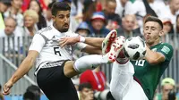 Gelandang Jerman, Sami Khedira, berebut bola dengan bek Meksiko, Hector Herrera, pada laga Grup F Piala Dunia di Stadion Luzhniki, Moskow, Minggu (17/6/2018). Meksiko menang 1-0 atas Jerman. (AP/Matthias Schrader)