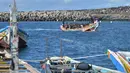 Sekelompok imigran yang kelelahan berjuang untuk menarik diri mereka ke pelabuhan La Restinga, sebuah desa nelayan di pulau kecil El Hierro di kepulauan Canary, Spanyol. (STRINGER / AFP)