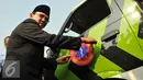 Basuki T Purnama menempelkan stiker di mobil ambulan saat peluncuran bus-bus baru dan hotline Transjakarta di monas, Jakarta, Senin (22/6/2015). Sebanyak 20 unit bus gandeng Transjakarta buatan eropa resmi diluncurkan. (Liputan6.com/Herman Zakharia)