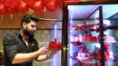 Pembuat kue memegang sebuah kue pada momen Hari Valentine di Damaskus, Suriah, Rabu (12/2/2020). (Xinhua/Ammar Safarjalani)
