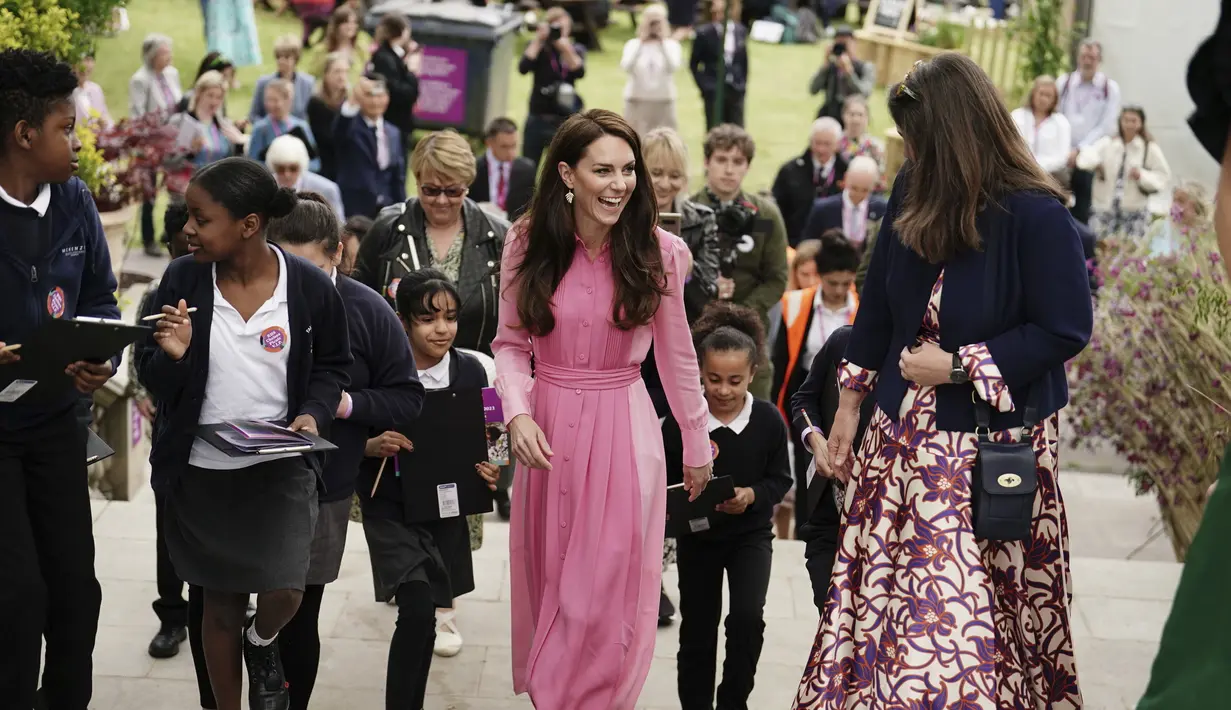 Dengan rambut cokelatnya yang tergerai, ibu tiga anak ini memadukan gaun tersebut dengan sepatu wedges Castaner Carina Espadrille dan anting-anting daun Zoraida seharga £165. (Jordan Pettitt/Pool via AP)