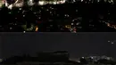 Foto kombinasi menunjukkan pemandangan kuil Parthenon kuno di atas bukit Acropolis sebelum (atas) dan selama Earth Hour di Athena, Yunani, Sabtu (30/3). (REUTERS/Costas Baltas)