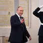 Presiden Rusia Vladimir Putin melambaikan tangan saat menjamu atlet Rusia peraih medali Olimpiade Musim Dingin Beijing 2022 dan anggota tim Paralimpiade negara itu di Kremlin di Moskow (26/4/2022). (AFP/NATALIA KOLESNIKOVA)