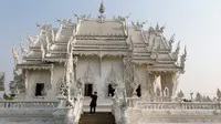 Turis saat melakukan tur di Wat Rong Khun atau kuil putih di Provinsi Chiang Mai, Thailand, Jumat (4/3). Kuil Putih dirancang oleh seniman visual Thai Chalermchai Kositpipat. (REUTERS / Jorge Silva)