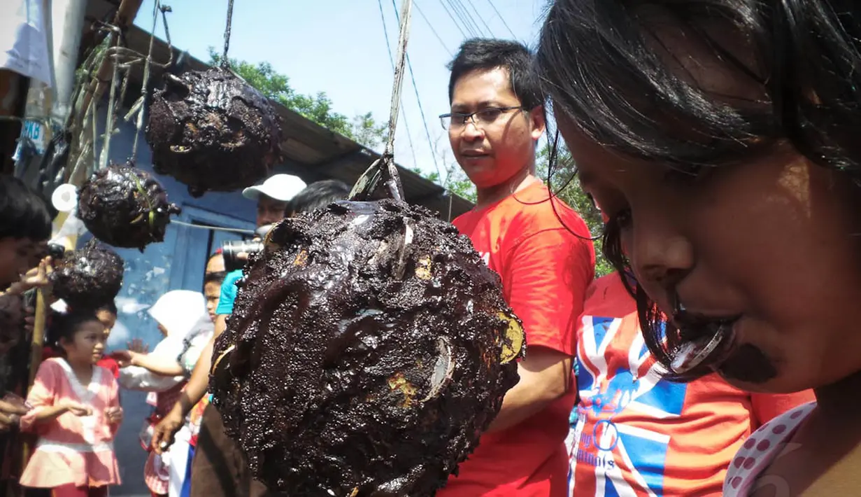 Anak-anak asyik menikmati permainan cabut koin dikawasan Cipinang Melayu, Jakarta, Minggu (17/8/14). (Liputan6.com/Faizal Fanani)