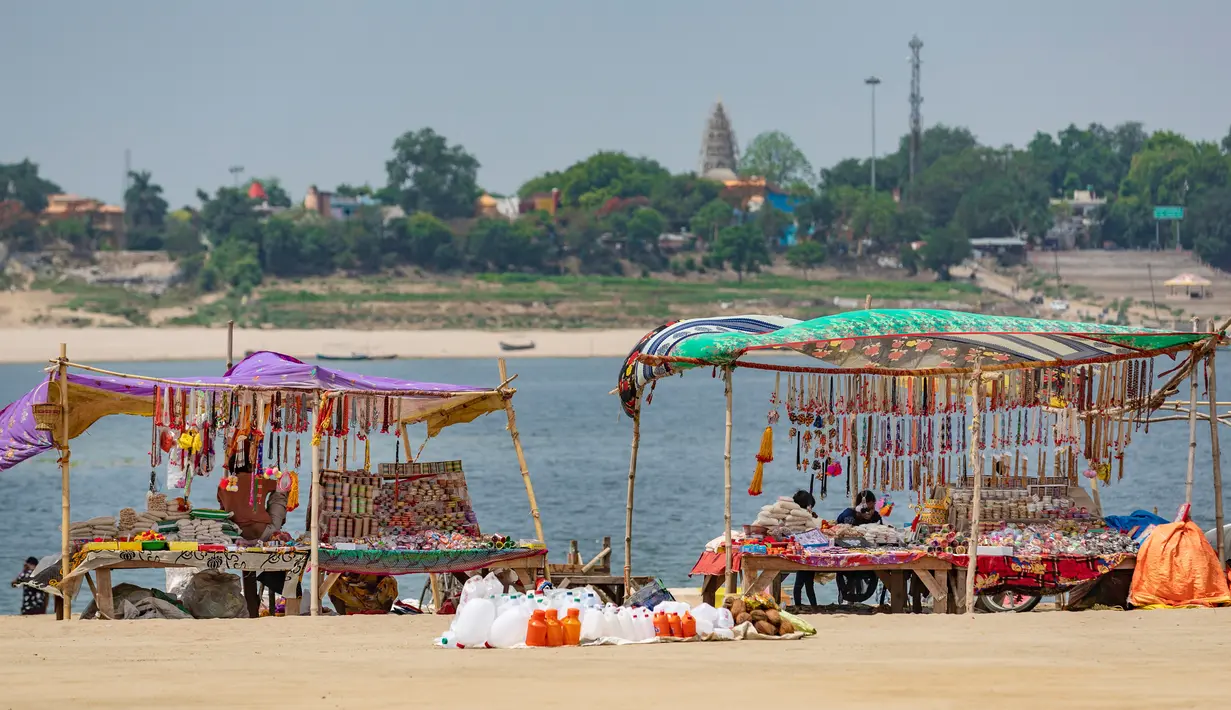 Kios-kios yang menjual bahan ibadah umat Hindu didirikan di Sungai Gangga, selama festival Gangga Dussehra, India (1/6/2020). Ratusan umat Hindu melakukan pencucian suci meskipun jemaat di tempat-tempat keagamaan terus dilarang selama penguncian coronavirus nasional. (AP Photo/Rajesh Kumar Singh)