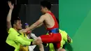 Lifter Tiongkok, Long Qingquan melompat ke pelatihnya setelah berhasil mengangkat beban pada cabang angkat besi putra selama Olimpiade Rio 2016 di Rio de Janeiro, Minggu (7/8). Long memecahkan rekor dunia usai menyabet medali emas. (REUTERS/Stoyan Nenov)