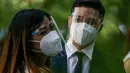 Pasangan mengenakan masker dalam "pernikahan massal bermasker" di sebuah taman di Filipina (15/12/2020). Pemerintah Filipina telah memberlakukan kebijakan untuk penggunaan masker di tengah kekhawatiran lonjakan kasus COVID-19 selama musim liburan. (Xinhua/Rouelle Umali)