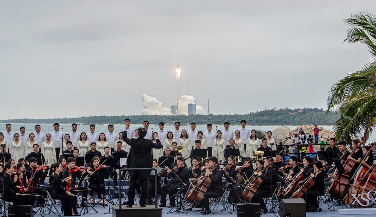 Band memainkan musik untuk mengiringi peluncuran roket Long March 5B yang membawa modul inti stasiun luar angkasa Tianhe dari Pusat Peluncuran Luar Angkasa Wenchang di Provinsi Hainan, China, Rabu (29/4/2021). China telah mengirimkan dua stasiun ruang angkasa sebelumnya ke orbit. (STR/AFP)
